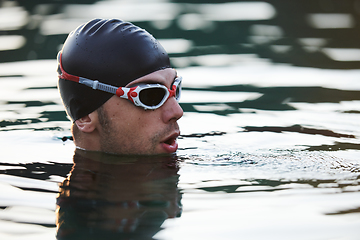 Image showing A triathlete finds serene rejuvenation in a lake, basking in the tranquility of the water after an intense training session