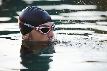 Image showing A triathlete finds serene rejuvenation in a lake, basking in the tranquility of the water after an intense training session