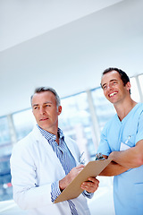 Image showing Doctors, men and clipboard in clinic together for thinking, space or vision for medical results. Medic team, partnership and checklist for wellness, healthcare or idea for problem solving at hospital