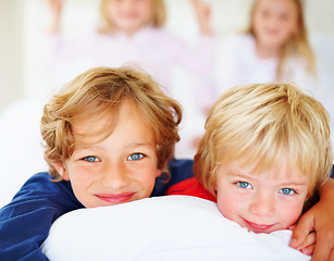 Image showing Portrait, children and happy for hug together on bed with relax wellness, trust and sibling support in home. Boys, face or smile for embrace in morning, blonde hair or blue eyes with bonding in house