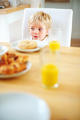 Image showing Kid, breakfast and bagel at home in the morning with food, smile and happy from eating. Family, dinner table and hungry young child with meal for health and nutrition in a house with orange juice