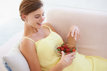 Image showing Pregnant woman, eating strawberries and happy in home, alone and enjoying delicious pregnancy craving. Good mood, fruit and maternity wellness with healthy food snack and nutrition satisfaction