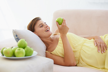Image showing Pregnant woman, apple and smile on sofa for health, nutrition and wellness in living room of apartment. Person, fruit and happy on couch of lounge for relax, pregnancy and healthy diet with vitamins