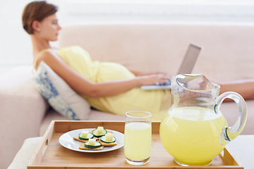 Image showing Pregnant woman, food or laptop on sofa with healthy, nutrition or wellness for lunch or snack in living room. Person, lemonade or brunch or technology on couch for remote work, relax or home internet