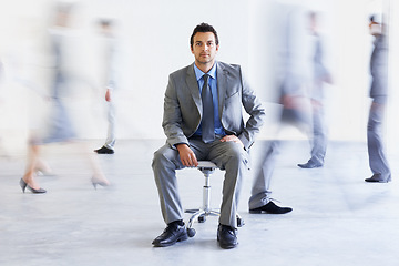 Image showing Portrait, chair and business man in busy office, workplace or corporate company. Motion blur, serious professional and employee coworking, confident lawyer and attorney in suit for career
