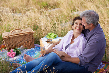 Image showing Old couple, relax and picnic in park for a date with love, care or support in marriage. Outdoor, man and woman on grass in nature with food, flowers and celebration in retirement, holiday or vacation