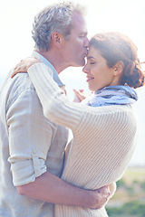 Image showing Old couple, forehead kiss and hug with love, respect or happiness on holiday in retirement. Mature, man and woman embrace together outdoor on vacation or show affection or gratitude in marriage