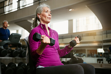 Image showing Senior fitness, dumbbell or old woman at gym for training, wellness or cardio with earphones, music or exercise. Weightlifting, bodybuilding and elderly female person at sports center for arm workout