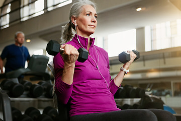 Image showing Old woman, fitness and dumbbells at gym for training, wellness and cardio with earphones, music or mindset. Weightlifting, bodybuilding and senior female person at a sports center for biceps workout