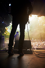 Image showing Musician, music festival and back on stage in outdoors, guitarist and event or energy for freedom at party. Person, concert or rave or performer, audio and playing or entertainment for audience