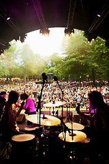 Image showing Band, concert and stage in outdoors, event and party or energy for freedom on vacation. People, drums and music festival or rave, audio and song for fun crowd and musicians with instruments for show