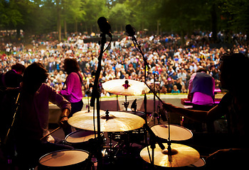 Image showing Band, concert and stage in outdoors, party and event or energy for freedom on vacation. People, drums and music festival or rave, audio and song for fun crowd and musicians with instruments for show