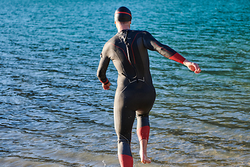 Image showing Triathlon athlete starting swimming training on lake