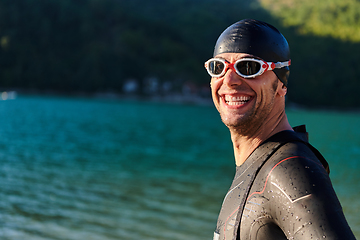 Image showing Authentic triathlon athlete getting ready for swimming training on lake