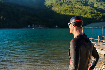 Image showing Authentic triathlon athlete getting ready for swimming training on lake