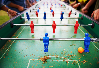 Image showing Playing, foosball and people outdoor with table, game or closeup on competition with ping pong ball. Soccer, board and small plastic football players or toys for social, event or sport at pub for fun