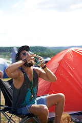 Image showing Man, drinking beer and fun in outdoors, music festival and alcohol and relaxing at party or camp. Male person, wine and crazy in nature, outside and freedom or energy for celebration at social event