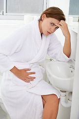 Image showing Nausea, pregnant woman and morning sickness in bathroom, unhappy and hand on stomach. Mirror reflection, moody and frustrated with illness, pregnancy and struggling with migraine pain on sink