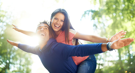 Image showing Outdoor, piggy back and couple with love, nature and summer with lens flare, marriage and adventure. Portrait, man carrying woman and woods for fun, playing and journey with relationship and romance