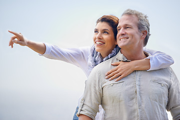 Image showing Happy couple, pointing and travel together with love, happiness and cruise adventure in summer. Retirement, vacation and mature man and woman hug and sightseeing on holiday with sky mockup space