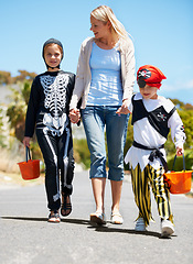 Image showing Mother, children and holding hands with Halloween costume, fun and playing with joy, cheerful or love. Outdoor, mama or kids with fantasy outfit, happiness or walking with a smile or family in street