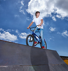 Image showing Riding, bike and teen on ramp for sport performance or event at park in summer with blue sky mockup. Bicycle, stunt or kid balance on edge of board for trick in cycling competition or challenge