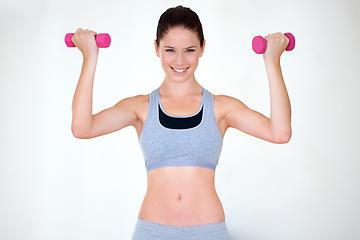 Image showing Woman, strong pose and portrait with dumbbells in studio, wellness and fitness for weight loss with exercise. Young person, flex and face with hand weights for muscle training and white background