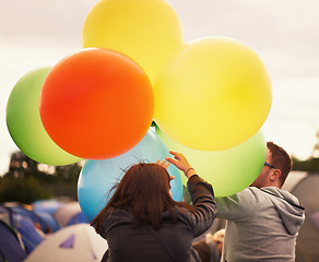 Image showing Music festival, celebration and people with balloons outdoor, camping and playing in woods. Party, man and woman at event with colorful, decoration for camp site and energy at carnival or concert