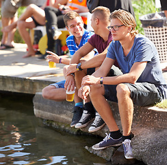 Image showing Drink, beer and people on holiday at lake, water or deck in summer at music festival with men. Friends, party and man relax and smoking at dam with alcohol, conversation or fun at event on pier