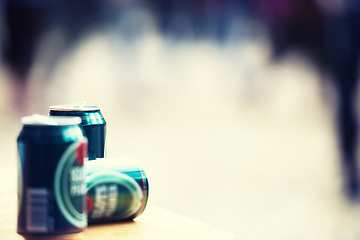 Image showing Space, blurred background and cans of beer closeup outdoor at a music festival for drinking or celebration. Party, product and alcohol with lager or ale at a carnival for the enjoyment of a beverage