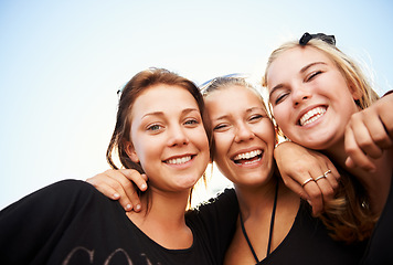 Image showing Friends, portrait and women hug outdoor for travel, bond and having fun on vacation, break or trip. Face, smile and group or people embrace outside for reunion, weekend or holiday hangout on blue sky