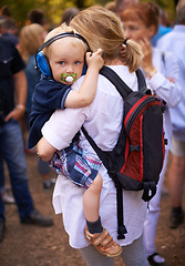 Image showing Outdoor, festival and mother with baby, headphones and protection with fun, music and audio. Family, toddler and mama with kid, childhood and ear mufflers with love, embrace and bonding together