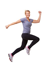 Image showing Woman, running and jump for fitness success, workout and training celebration, energy or achievement in studio. Portrait of sports model or runner in air for exercise and cardio on a white background