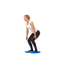 Image showing Balance, squat and fitness with woman on disk in studio for workout, health or exercise. Wellness, challenge and training with female person on white background for flexibility, smile or aerobics