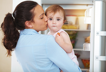 Image showing Happy woman, mother and toddler with kiss in kitchen, fridge and eating of snack for hunger. Kid, little girl and hungry with fresh, organic or fruit for nutrition, vegetarian or healthy diet in home
