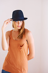 Image showing Fashion, portrait and woman with hat in studio for fancy or confidence with cool outfit on wall background. Face, attitude or female model pose with bowler, clothes or vintage and retro style