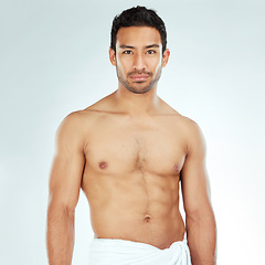 Image showing Body, chest and portrait of asian man in a towel in studio for cleaning, hygiene and care on white background. Face, confidence muscular Japanese model with glowing skin grooming results after shower