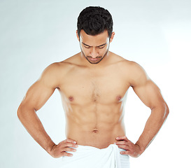 Image showing Body, cleaning and asian man in a towel in studio for wellness, hygiene or grooming on white background. Stomach, chest and male model checking fitness results, progress or sixpack muscle development