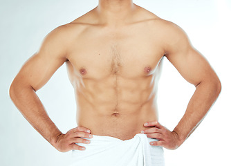 Image showing Body, closeup and fitness man in a towel in studio for shower, wellness or grooming on white background. Chest, stomach and male model relax in a bathroom for cosmetic, care or cleaning with sixpack