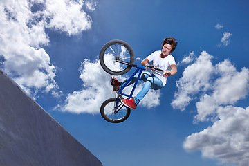 Image showing Ramp, jump and man with bike in sky at park, event or competition for sport with risk and energy. Mockup, space and person in air with trick or stunt on bicycle for fun in summer with adventure