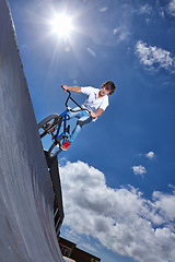Image showing Ride, bike and teen on ramp for sport performance, jump or training for event at park with blue sky mockup. Bicycle, stunt or kid balance on edge of board in trick for cycling competition challenge