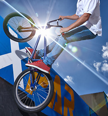 Image showing Ramp, trick and man with bicycle in air at park, event or competition for sport with risk and balance. Mockup, space or person in sky with fearless stunt on bike for fun adventure or action in summer