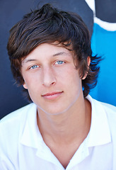 Image showing Cool, teenager and portrait of skater on wall in summer, vacation or relax outdoor on holiday. Urban, teen and face of serious kid with edgy fashion, long hairstyle and streetwear for skatepark