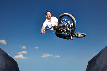 Image showing Ramp, jump and man with bike in sky at park, event or competition for sport with risk and energy. Mockup, space and person in air with trick or stunt on bicycle for fun in summer with adventure