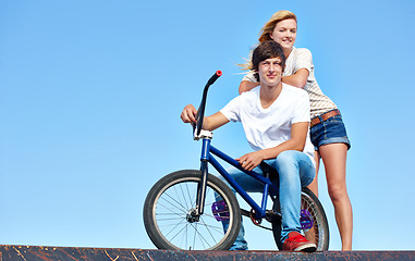 Image showing Happy, friends and portrait of teenager at skatepark in summer on vacation or holiday with bicycle on sky. Cool, girl and boy on ramp with bike and smile for fun ride together in city mock up space