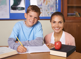 Image showing Happy teacher, student and portrait in support for education, learning or tutor in classroom at school. Woman, mentor or teaching boy with smile in writing exam, literature or test for help in class