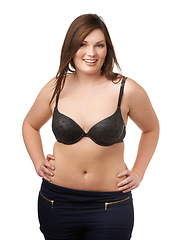 Image showing Portrait, happy and bra with a plus size woman in studio isolated on a white background for body positivity. Beauty, smile and a confident young model looking natural in her underwear for wellness