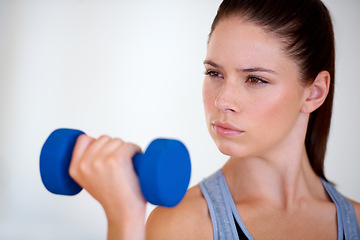 Image showing Woman, serious and exercise with dumbbells in studio, health wellness and fitness for weight loss. Young person, thinking or commitment with workout for tone muscle or training on white background