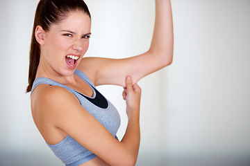 Image showing Fitness, arm and woman holding her fat for health, wellness and weight loss goals in a studio. Shout, scream and portrait of young female person showing bicep body for exercise or workout motivation