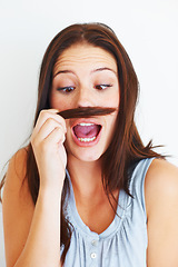 Image showing Woman, silly and playing with hair mustache by white background, hairstyle and funny joke in studio. Female model person, comic and comedy for haircare or goofy, beauty treatment and cosmetology